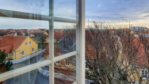 A view from a window overlooking a residential area with houses and a clear sky.