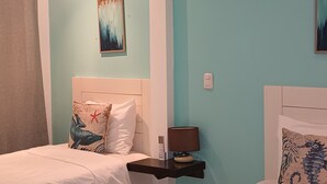 A room with two beds, a nightstand, a painting, and a ceiling light. - 2-bedroom resort in wonderful Playas del Coco with WiFi, AC; extra sleeper  (Playas del Coco)