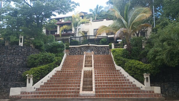 A staircase leading up to a building with a stone wall on one side and a metal railing on the other. - 2-bedroom resort in wonderful Playas del Coco with WiFi, AC; extra sleeper  (Playas del Coco)
