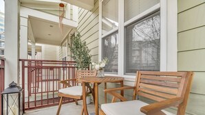 Un espace extérieur aménagé avec des meubles en bois, comprenant une table et des chaises, une lanterne et une plante en pot.