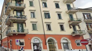 A multi-story building with balconies, a shop on the ground floor, and a no parking sign. - Vitti's home Verona 5 (Verona)
