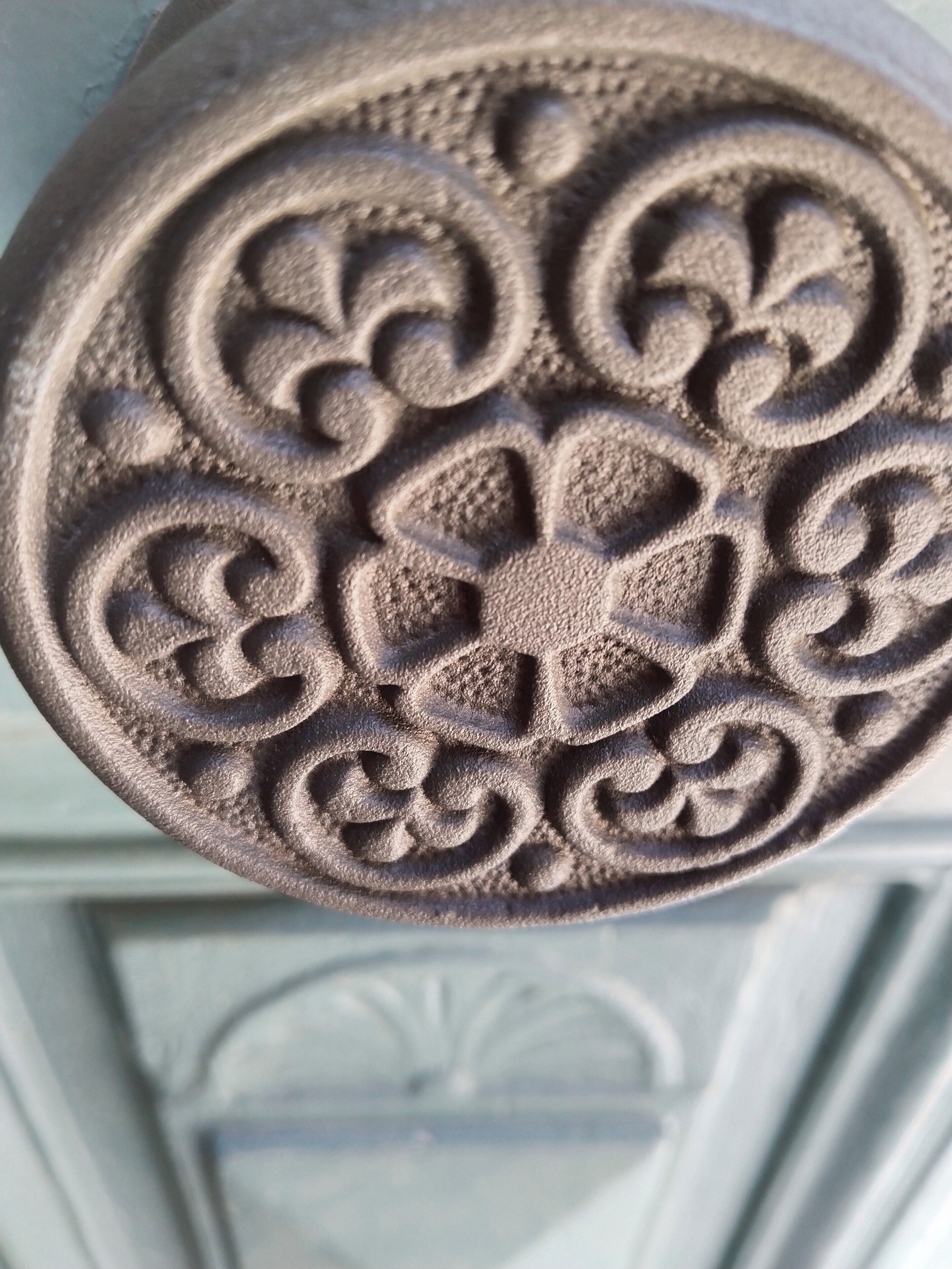 Primeiro plano de uma escultura em pedra decorativa com padrões complexos.