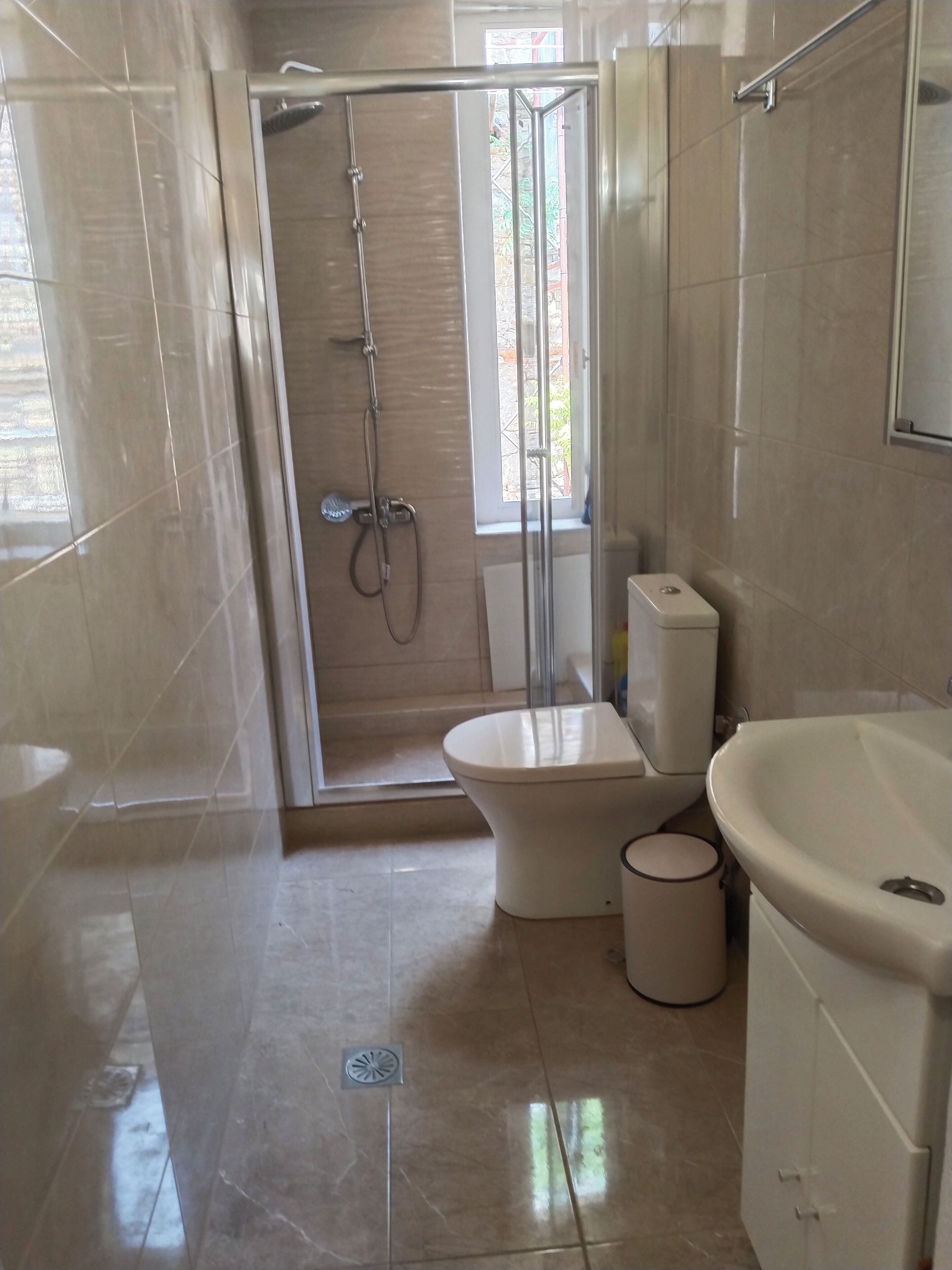 Une salle de bain moderne avec une douche à parois de verre, des toilettes et un lavabo.