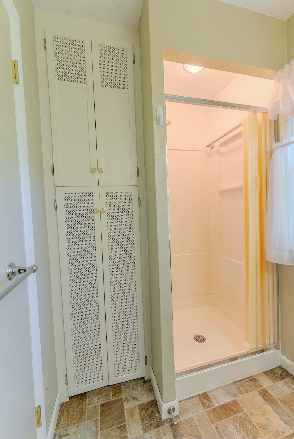 A bathroom with a walk-in shower, a toilet, and a sink.
