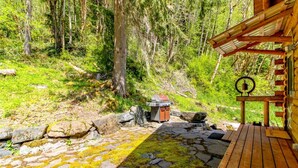 Eine Holzterrasse mit einem Steinweg, der zu einer rustikalen Holzhütte führt.