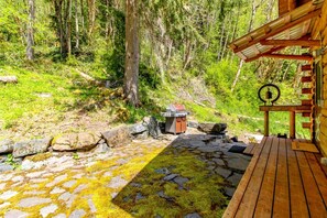 Une terrasse en bois avec un chemin de pierre menant à un chalet rustique.