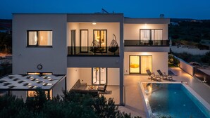 A modern two-story house with a swimming pool, outdoor seating, and large windows. - Awesome home in Primosten (Primosten)