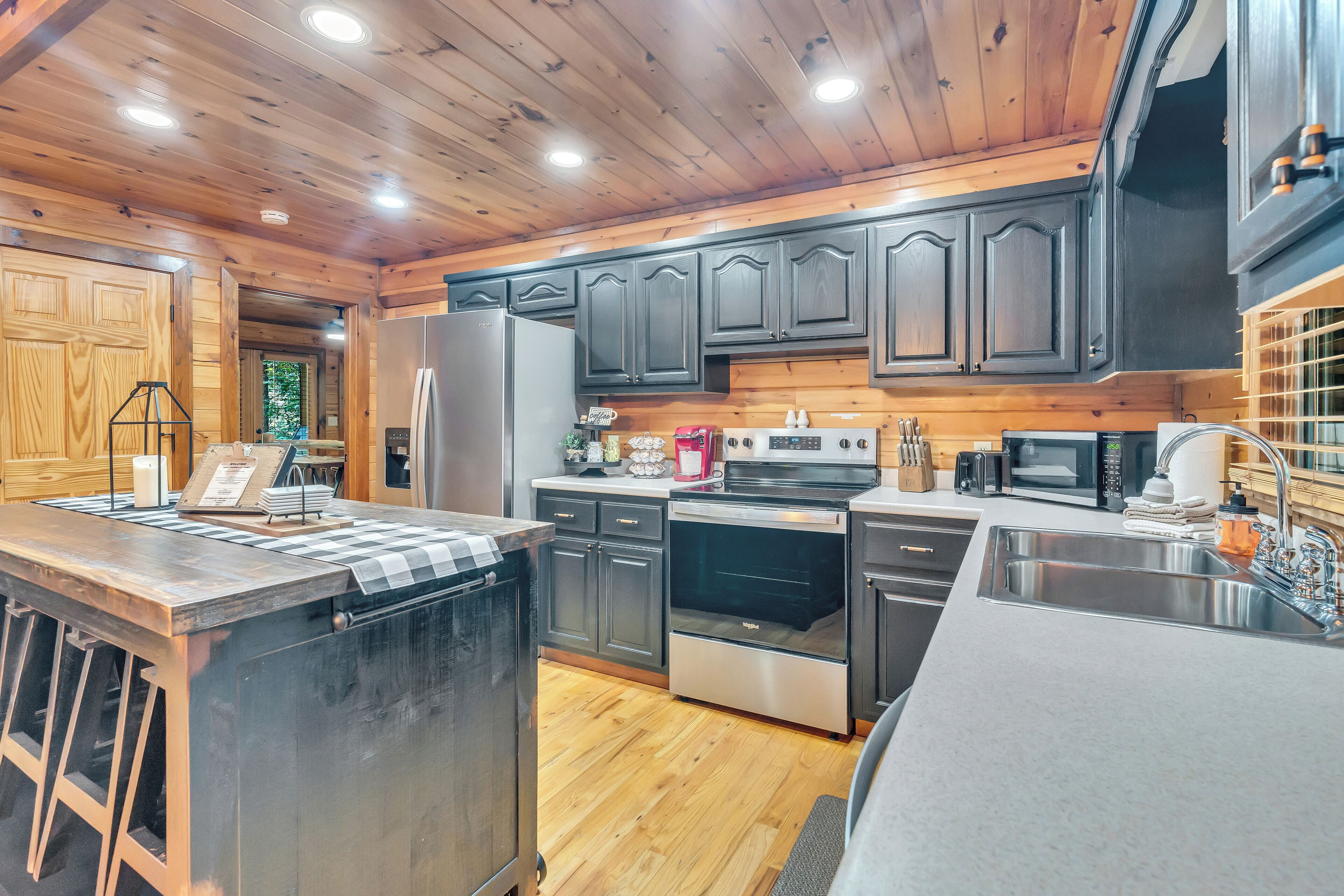 A modern kitchen with wooden cabinets, stainless steel appliances, and a central island.