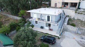 A two-story building with a balcony, a car parked in front, and a green roof. - Charming 2-bedroom house with AC, WiFi in amazing Corfu






 (Corfu)