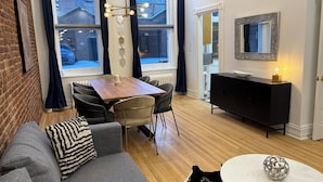 A modern living room with a sofa, a dining table, and a black cabinet. - Vieux Quebec- au cœur - Old Quebec (Québec)