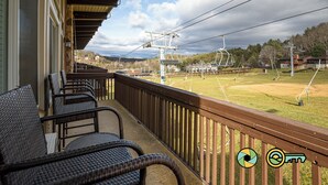 A balcony with wicker furniture overlooking a ski resort. - Lavender Lodge (#237) On ski slope | Triple-decker bunk beds! (Basye)