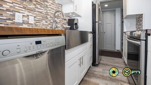 A modern kitchen with a Bosch dishwasher, stainless steel appliances, and a patterned backsplash. - Lavender Lodge (#237) On ski slope | Triple-decker bunk beds! (Basye)