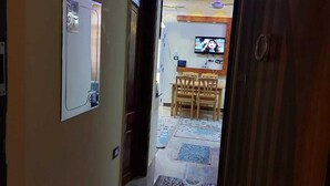 A hallway leading to a dining area with a television mounted on the wall. - Star Apartment Hurghada (Hurghada)