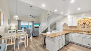 A modern kitchen with white cabinetry, a granite countertop, and a central island.