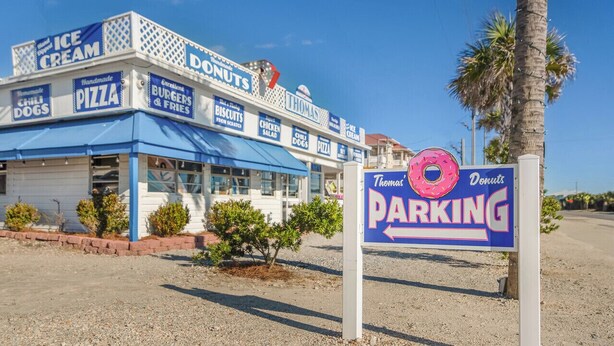 A food truck with signs for ice cream, donuts, pizza, and chili dogs.