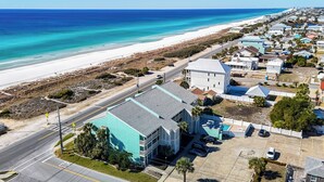 A coastal residential area with a beachfront, houses with blue roofs, and a clear view of the ocean. - Laguna Beach Condo with Spectacular Gulf Views (Panama City Beach)