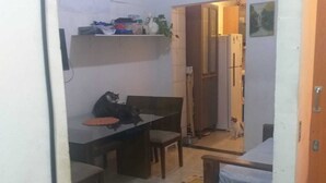 Een ruimtelijke woonruimte met een eethoek, een kleine kitchenette en een slaapgedeelte.