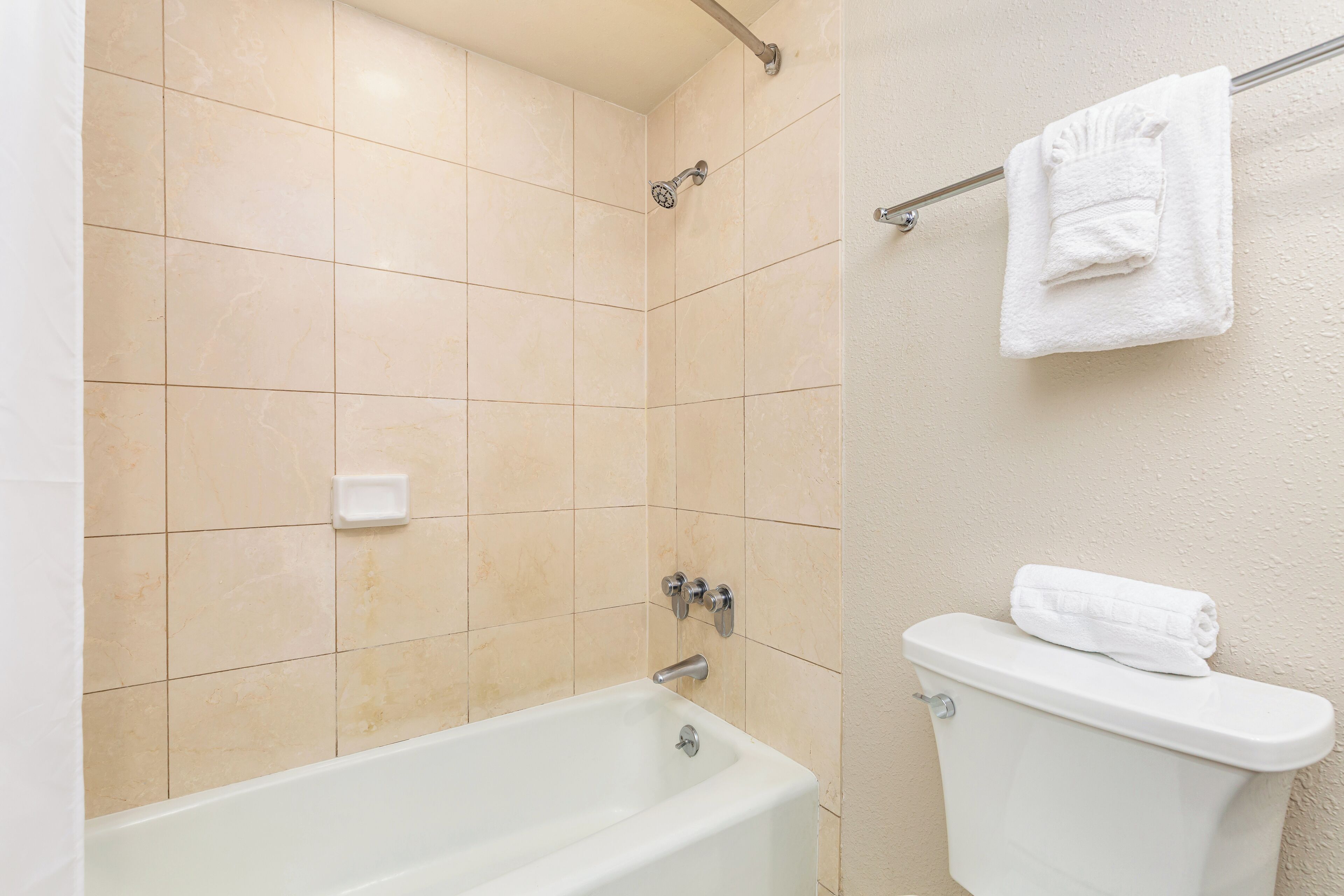 Un bagno con una vasca, un water e un asciugamano appeso a un portasciugamani.