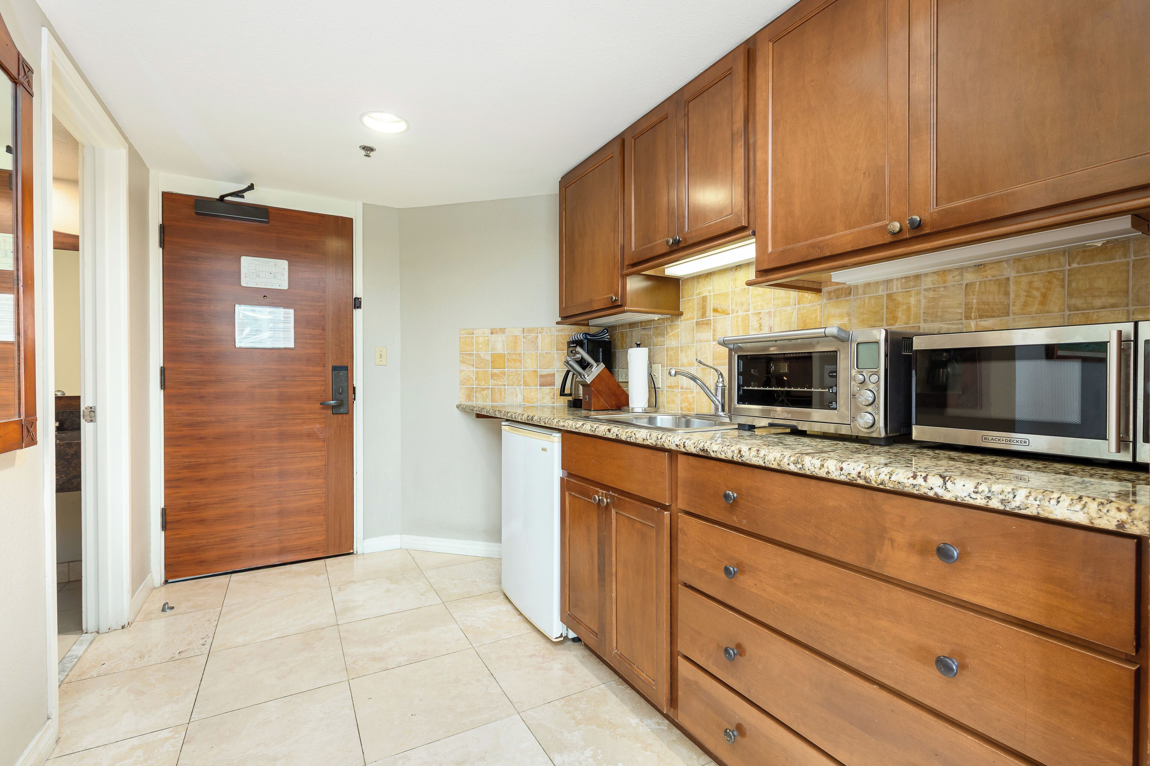 A kitchen with wooden cabinets, a microwave, and a dishwasher.
