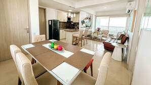 A modern kitchen with a dining area, a black refrigerator, and a dining table with chairs. - In bocagrande and luxurious apartment in Cartagena (Cartagena de Indias)