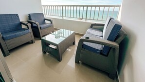 A balcony with wicker furniture, a glass table, and a view of the sea. - In bocagrande and luxurious apartment in Cartagena (Cartagena de Indias)