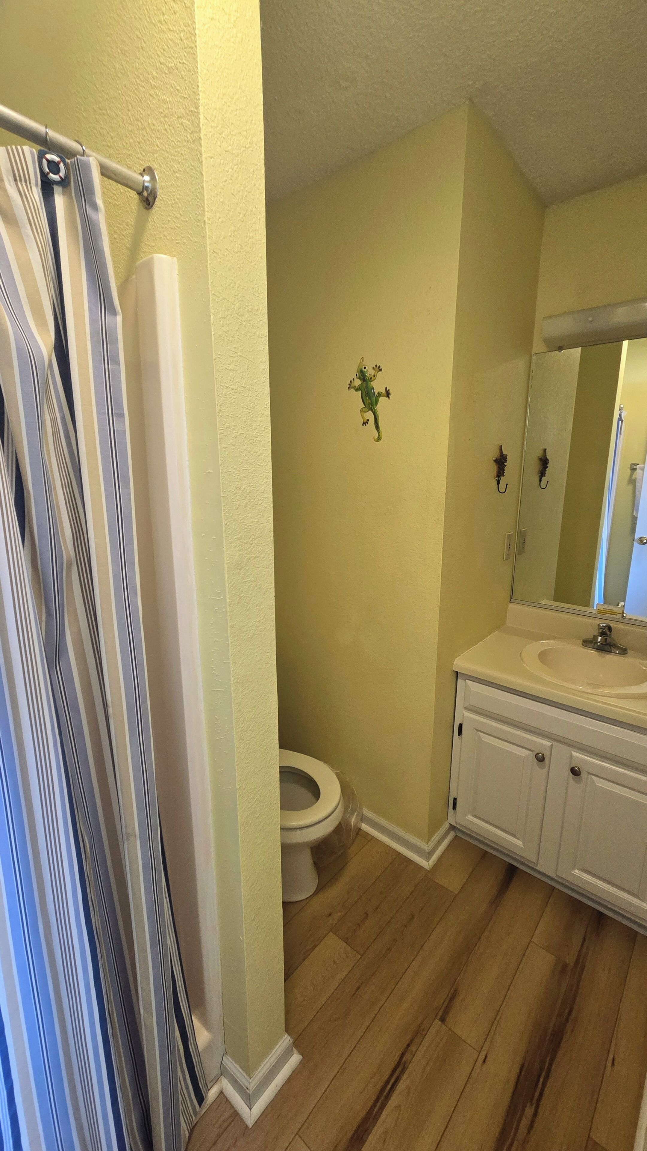 Un baño con inodoro, lavamanos y cortina de ducha.
