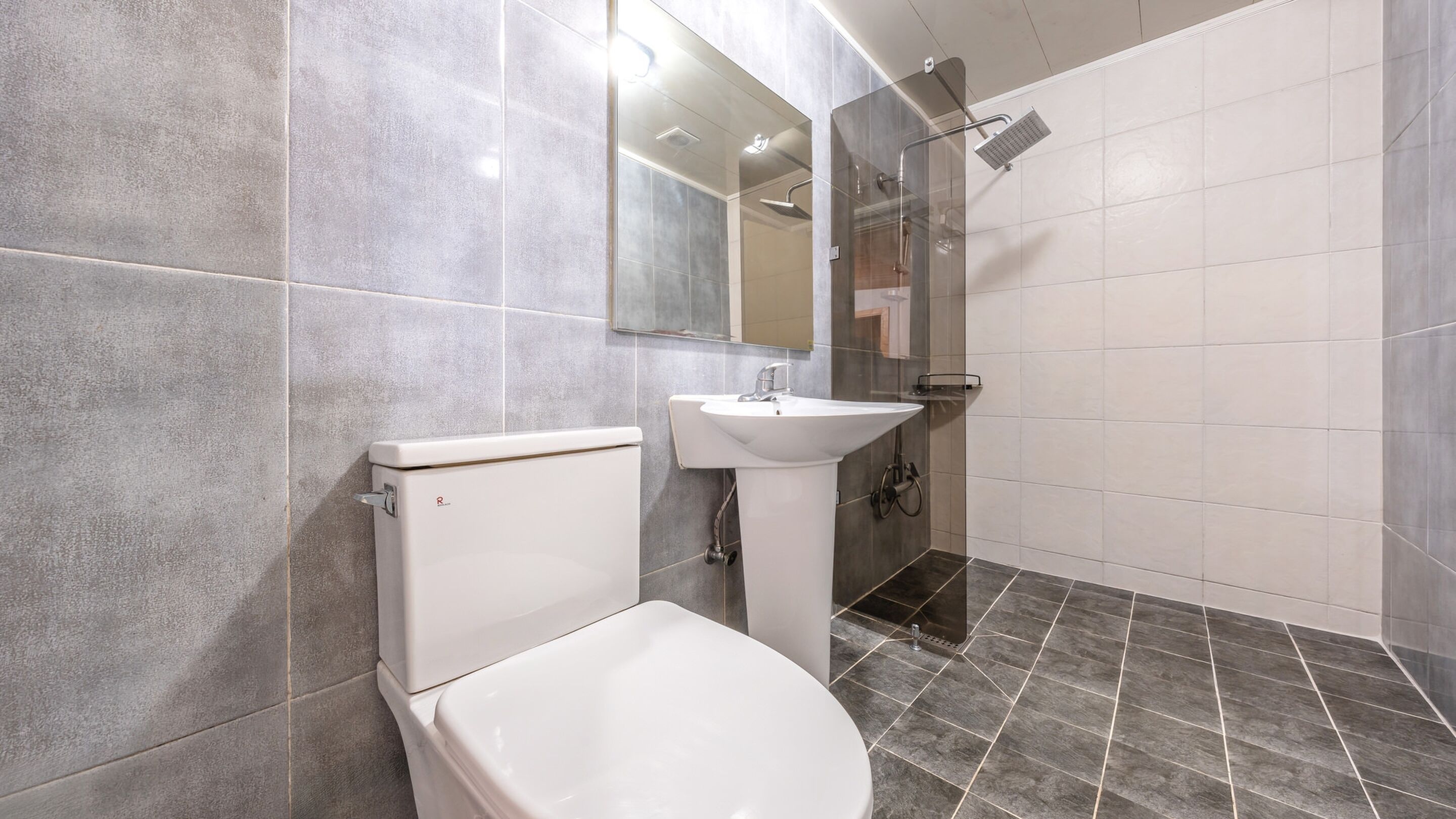 Ein modernes Badezimmer mit Toilette, Waschbecken und Dusche.