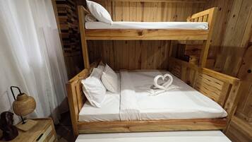 Uma cama beliche de madeira com uma toalha em formato de coração na cama inferior.