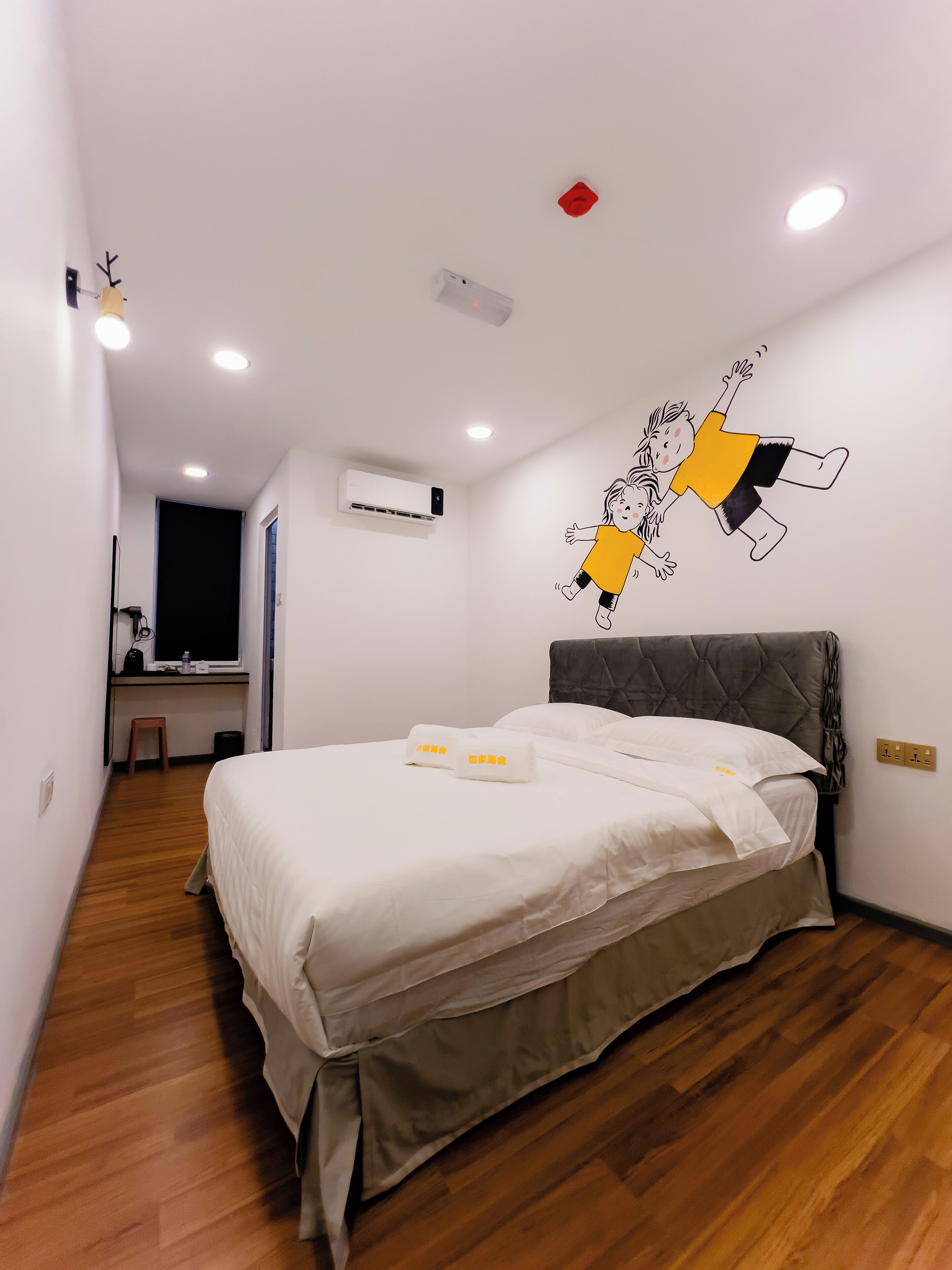 A hotel room with a bed, a desk, and a chair.