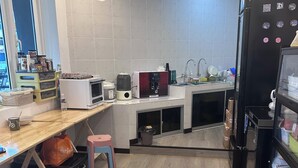 A modern kitchen with a wooden countertop, a sink, a refrigerator, and a microwave. - Ru Jia Hai She Hotel (Semporna)