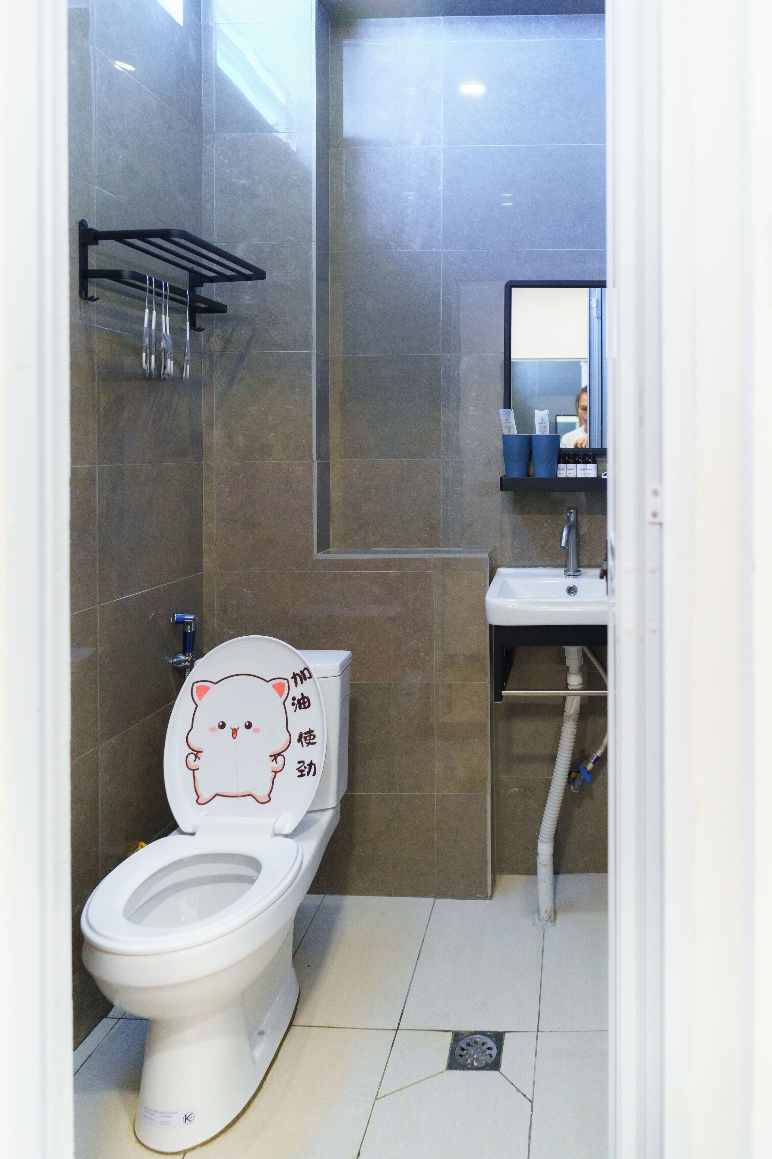 Un baño con inodoro, lavamanos y paredes con azulejos.