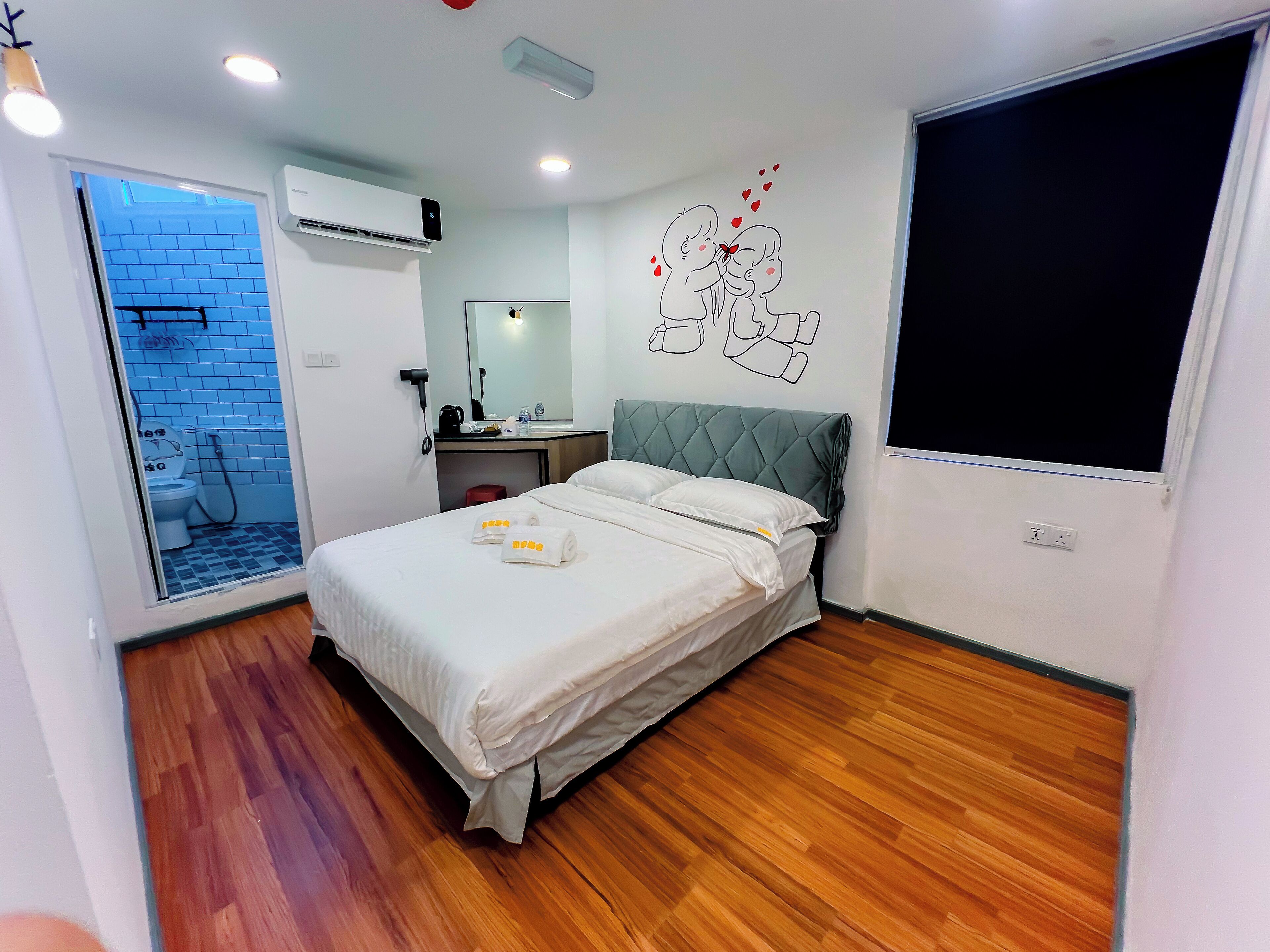 Ein Hotelzimmer mit einem Bett, einem Badezimmer mit Dusche, einem Schreibtisch und einem großen Fenster.