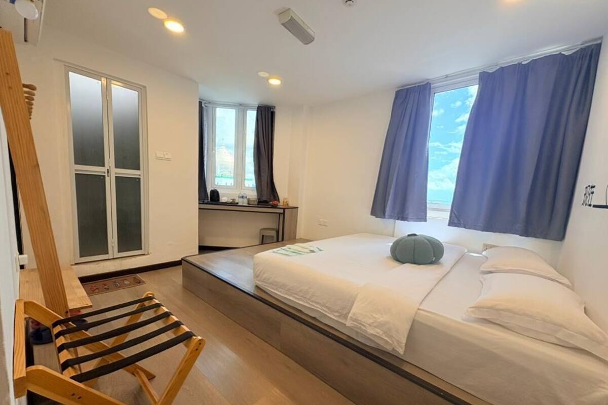 A compact room with a bed, a desk, and a chair.