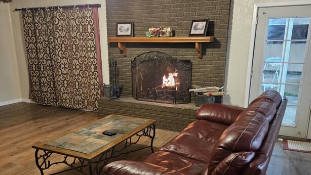 Una sala de estar con chimenea, un sofá de cuero y una mesa de centro de madera.