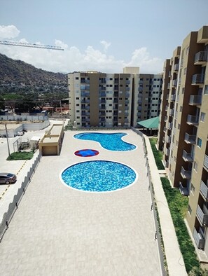 Enjoy a refreshing swim in the rooftop pool with three unique sections, surrounded by a hilly landscape.