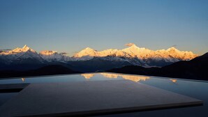 Paisaje montañoso con cielo despejado y superficie reflectante en primer plano.