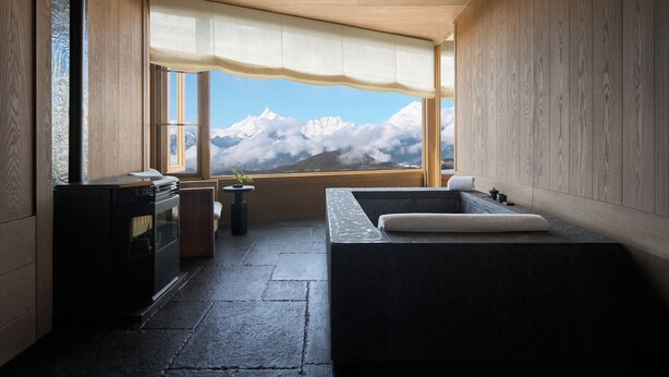 Un baño con un ventanal grande, una bañera y una estufa.