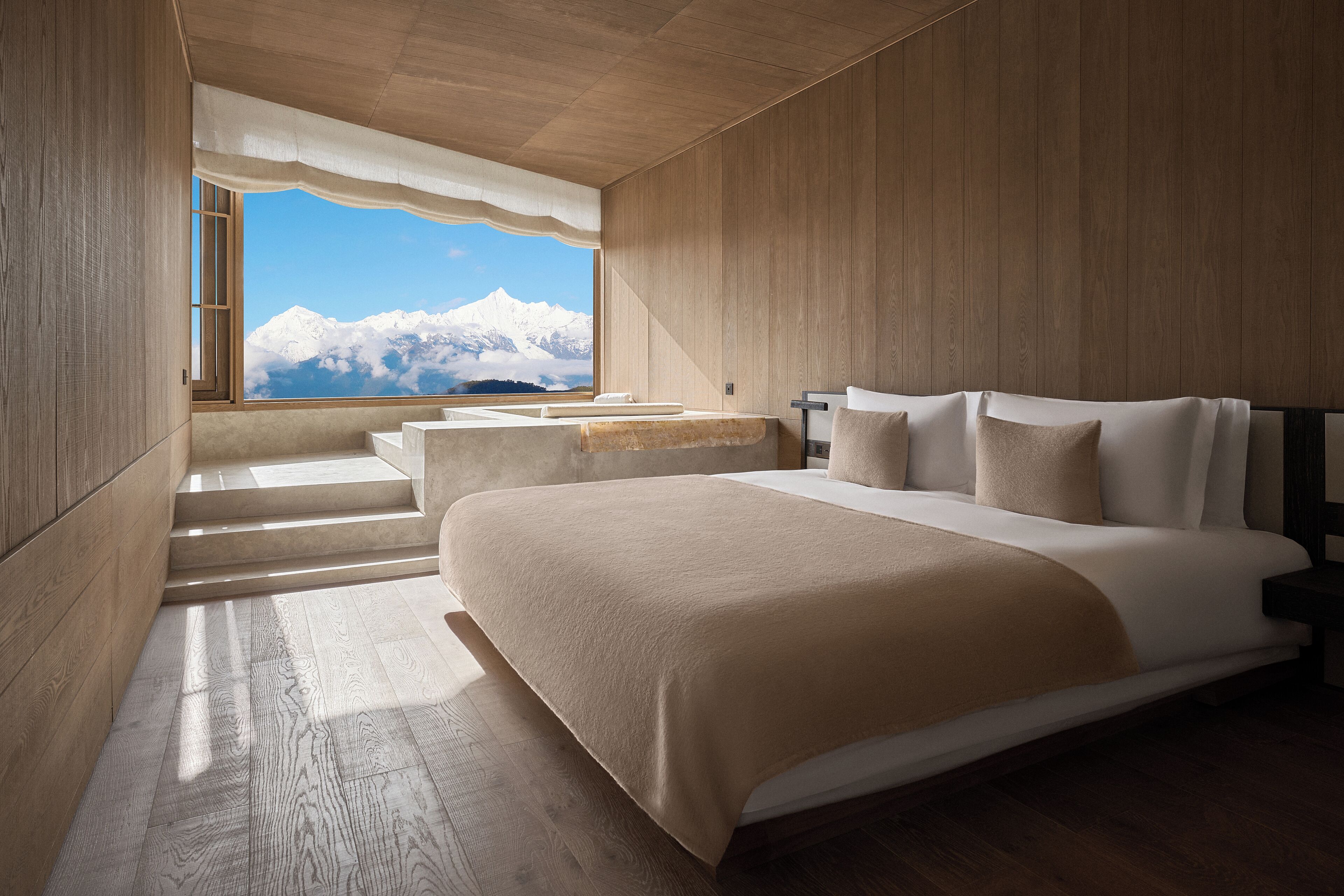 Ein Schlafzimmer mit einem großen Bett, einem Fenster mit Bergblick und Holzwänden.