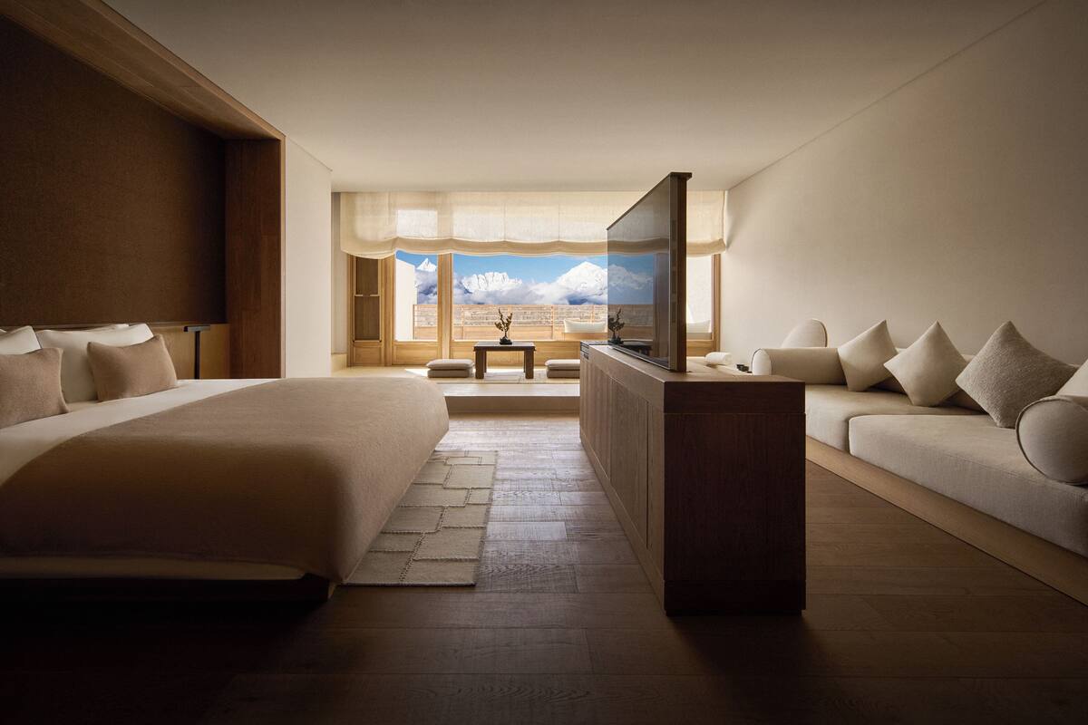 Une chambre d’hôtel avec un grand lit, un canapé, une télévision et une vue sur les montagnes.