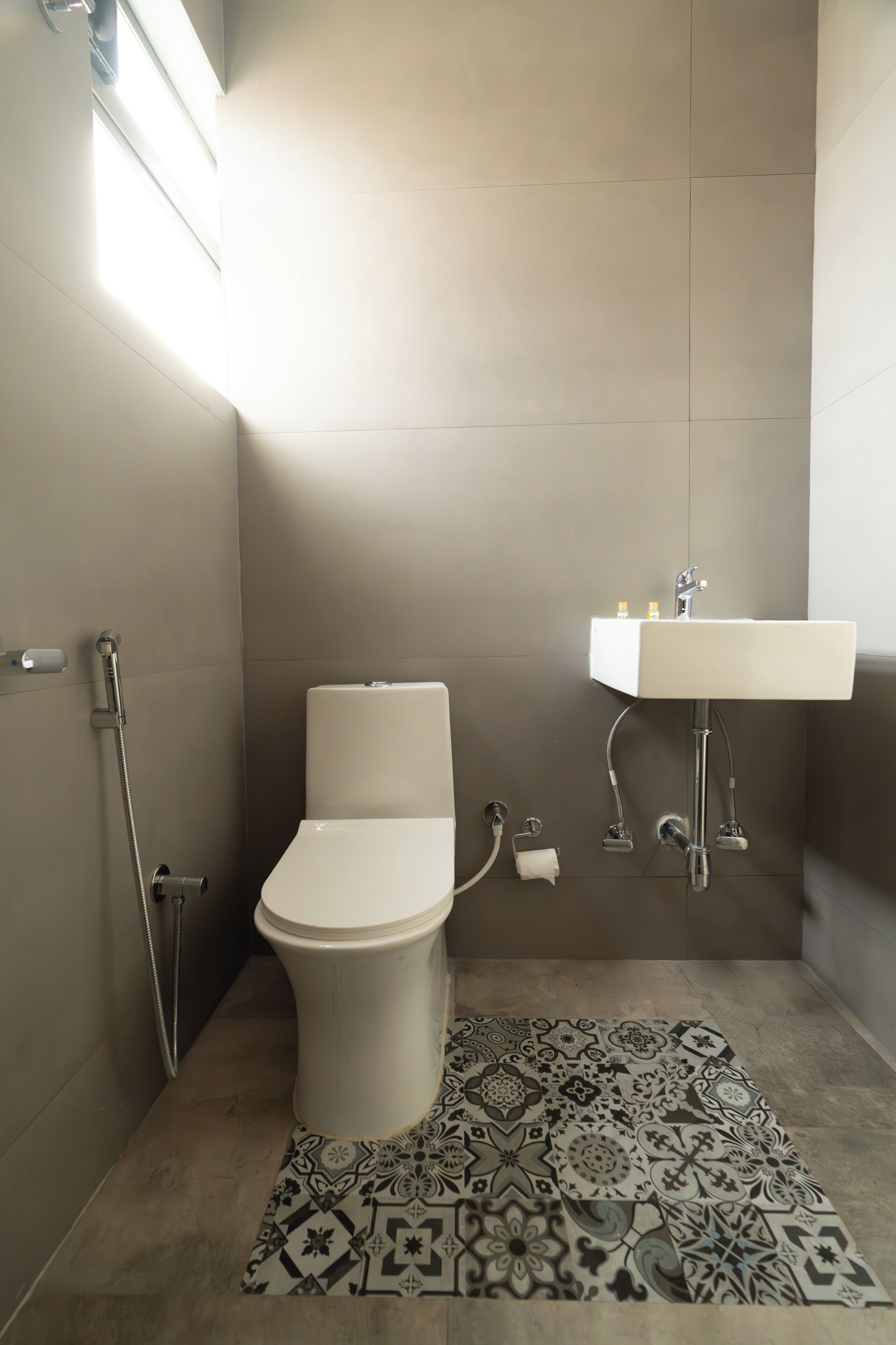 A modern bathroom with a toilet, shower, and sink.