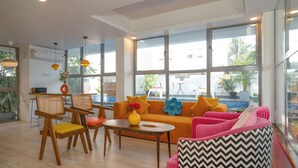 Ein helles Wohnzimmer mit einer Couch, Sesseln und einem Couchtisch.