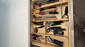Eine Küchenschublade mit verschiedenen Utensilien und Küchenwerkzeugen.