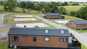 A modern building with a flat roof, multiple windows, and a covered outdoor seating area. - 2 bedroom accommodation in Old Langho, Ribble Valley (Old Langho, Ribble Valley)