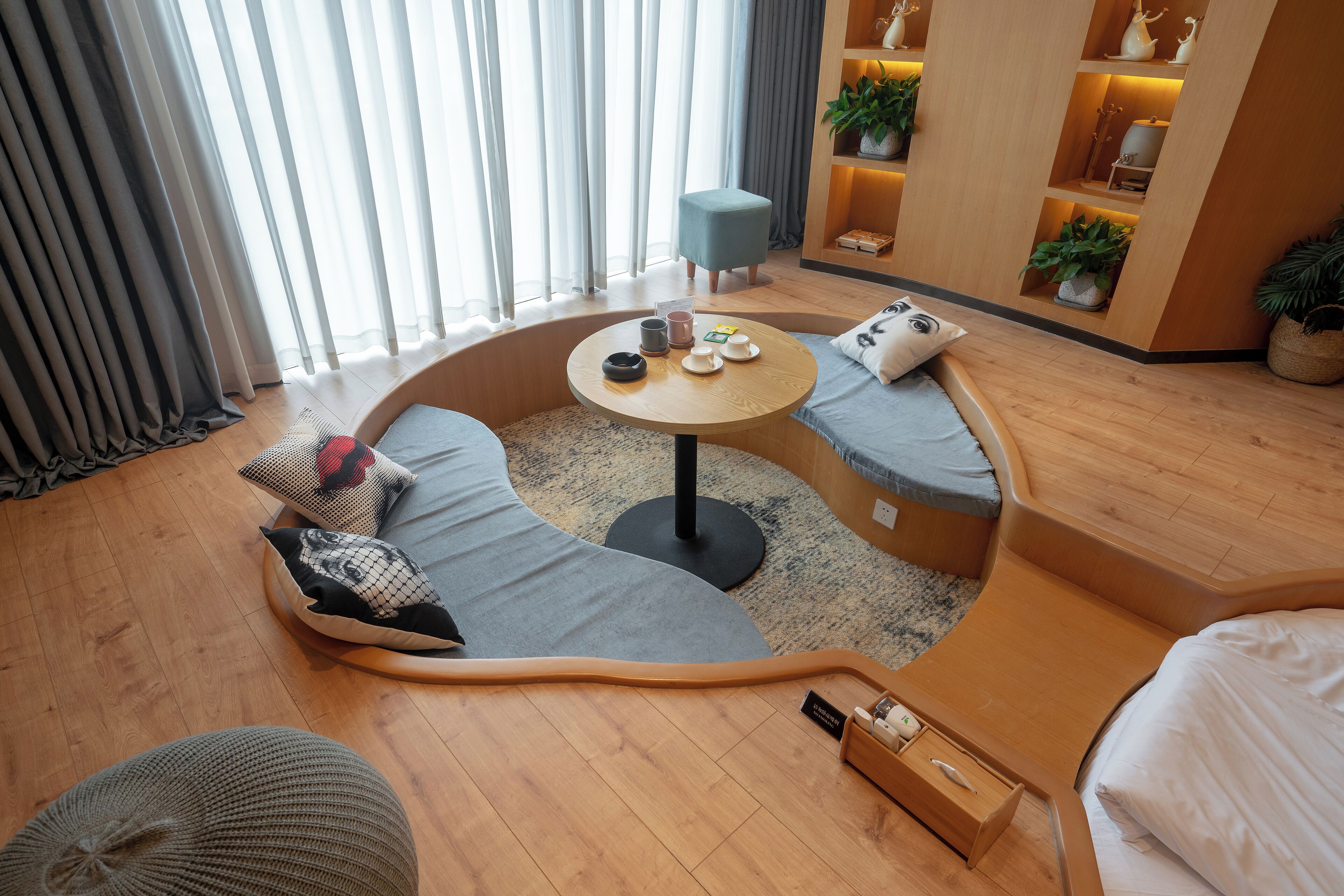 A modern living room with a curved sofa, a round coffee table, and a small side table.