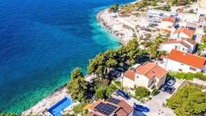 A coastal residential area with houses, clear blue waters, and a rocky shoreline. - Apartment Tina by Interhome (Trogir/Okrug Gornji)