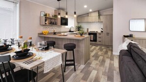 Une cuisine moderne dotée d’un îlot central, de meubles en bois et de luminaires suspendus.