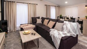 Un salon comprenant un canapé, une table basse, une cheminée et un coin repas.