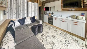 A modern living room with a sofa, a coffee table, and a patterned rug. - 2 bedroom accommodation in Gartmore (Gartmore)