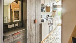 A modern kitchen with wooden cabinetry, a built-in oven, and a tiled backsplash. - 2 bedroom accommodation in Gartmore (Gartmore)