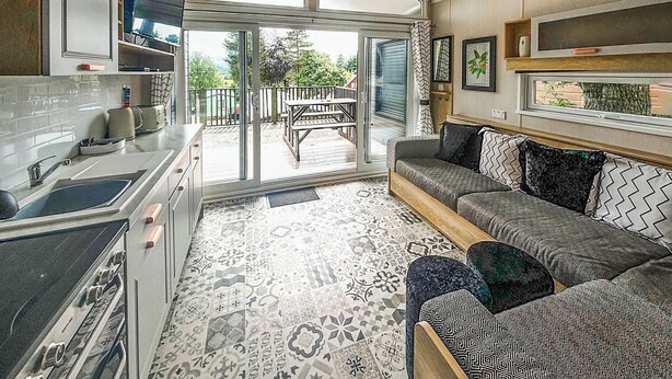 A compact kitchen with a sink, stove, and dining area. - 2 bedroom accommodation in Gartmore (Gartmore)